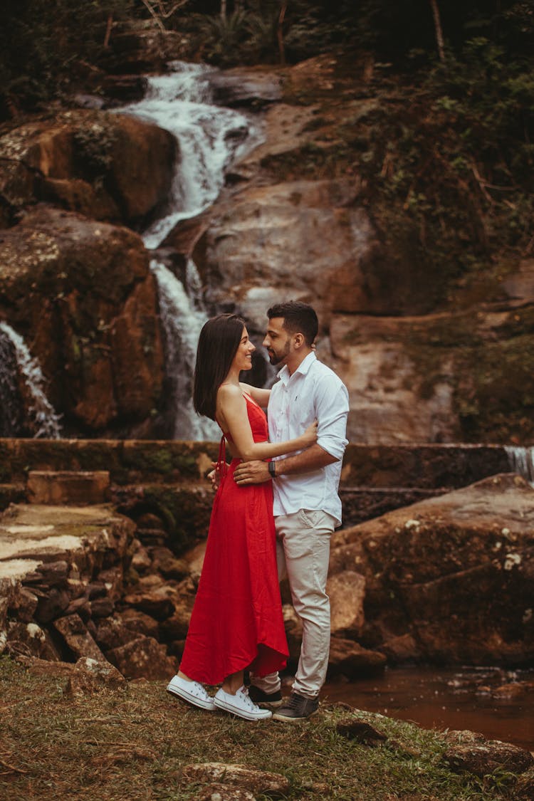 Man And Woman Hugging Near A Waterfall