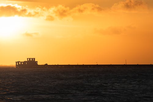 Silhouette of Building at End of Pier at Sunset