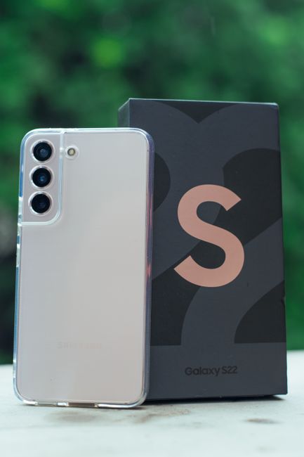 Close-up image of Samsung Galaxy S22 with its box in an outdoor setting.