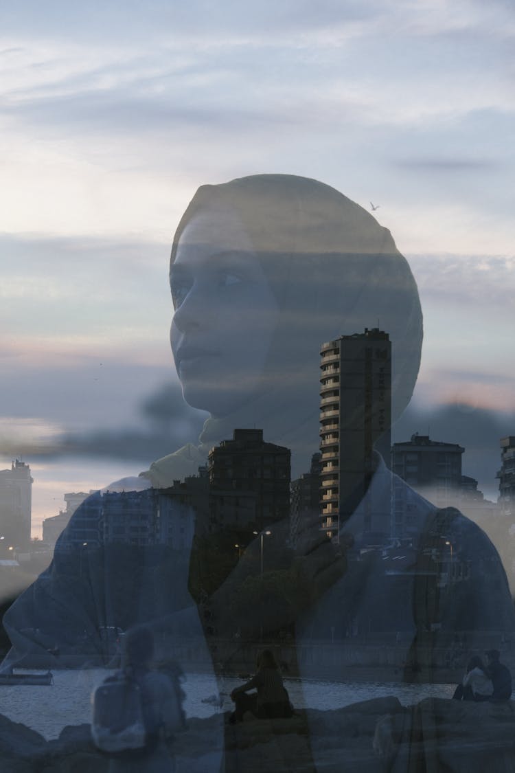 Reflection Of Woman In Window On City Background