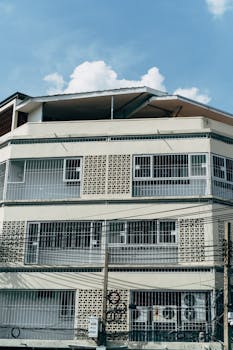 Photo of a modern apartment building with a unique facade against a blue sky backdrop.