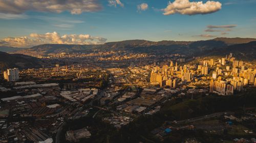 Free Stunning aerial view of Medellín's urban skyline surrounded by mountains at sunset. Stock Photo