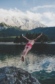 在德国格莱瑙，一名男子跳入了被雄伟山脉环绕的宁静湖中