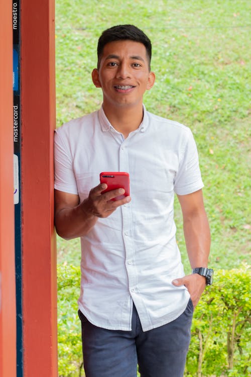 Man in White Button Up Shirt Holding Red Smartphone