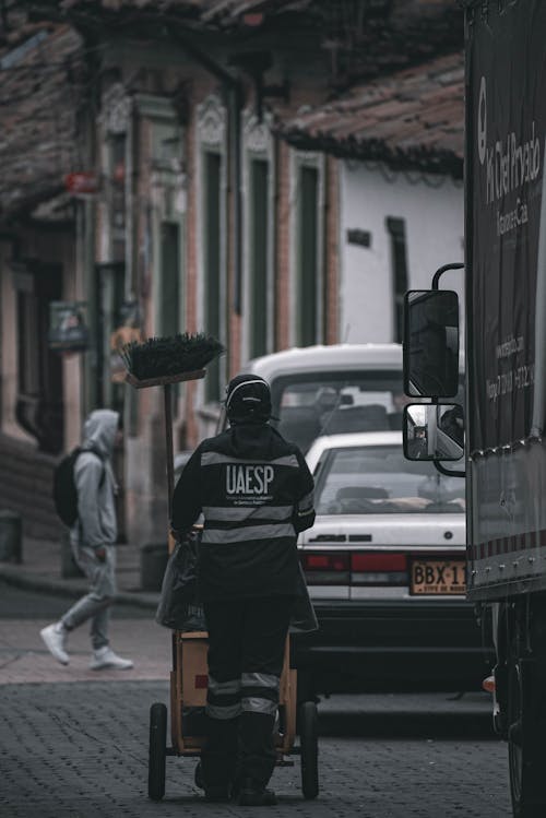 Back View of a Cleaner Pushing a Cart on the Street