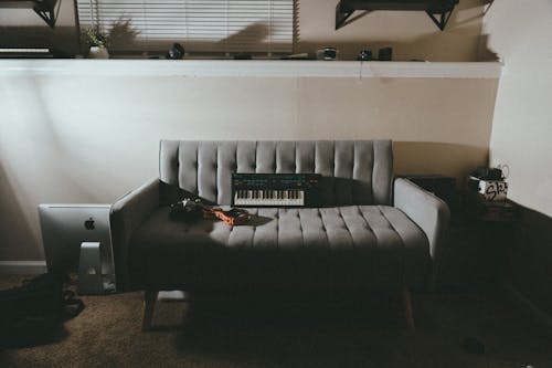 Keyboard on a Grey Sofa in a Living Room 