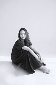 Stylish black and white portrait of a young woman in a dress with copy space.