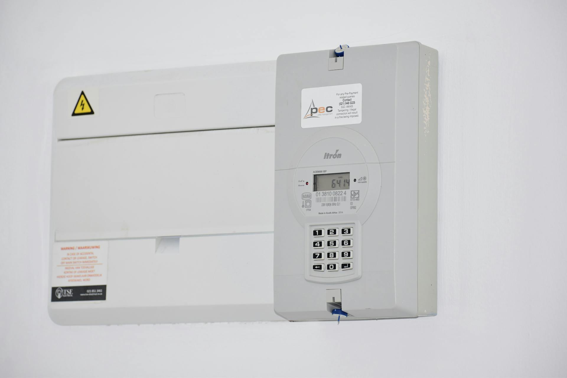 Electrical meter and fuse box on a white wall in Cape Town, South Africa, for energy monitoring or billing.