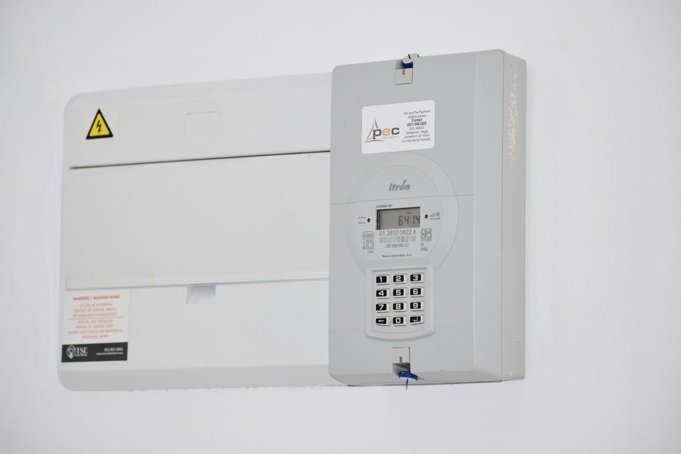A modern white switchboard and meter box on a wall
