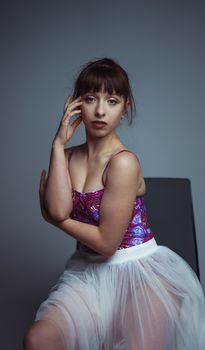 Elegant portrait of a ballerina wearing a stylish tulle dress in a studio setting.