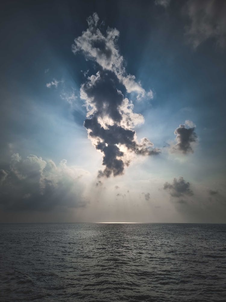 Sun Through Clouds Above Sea