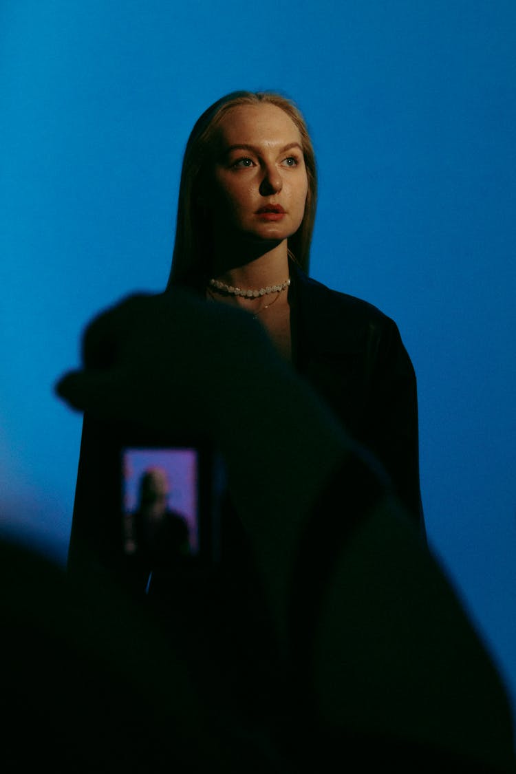 Woman In Black Dress Photo Session On Blue Studio Background