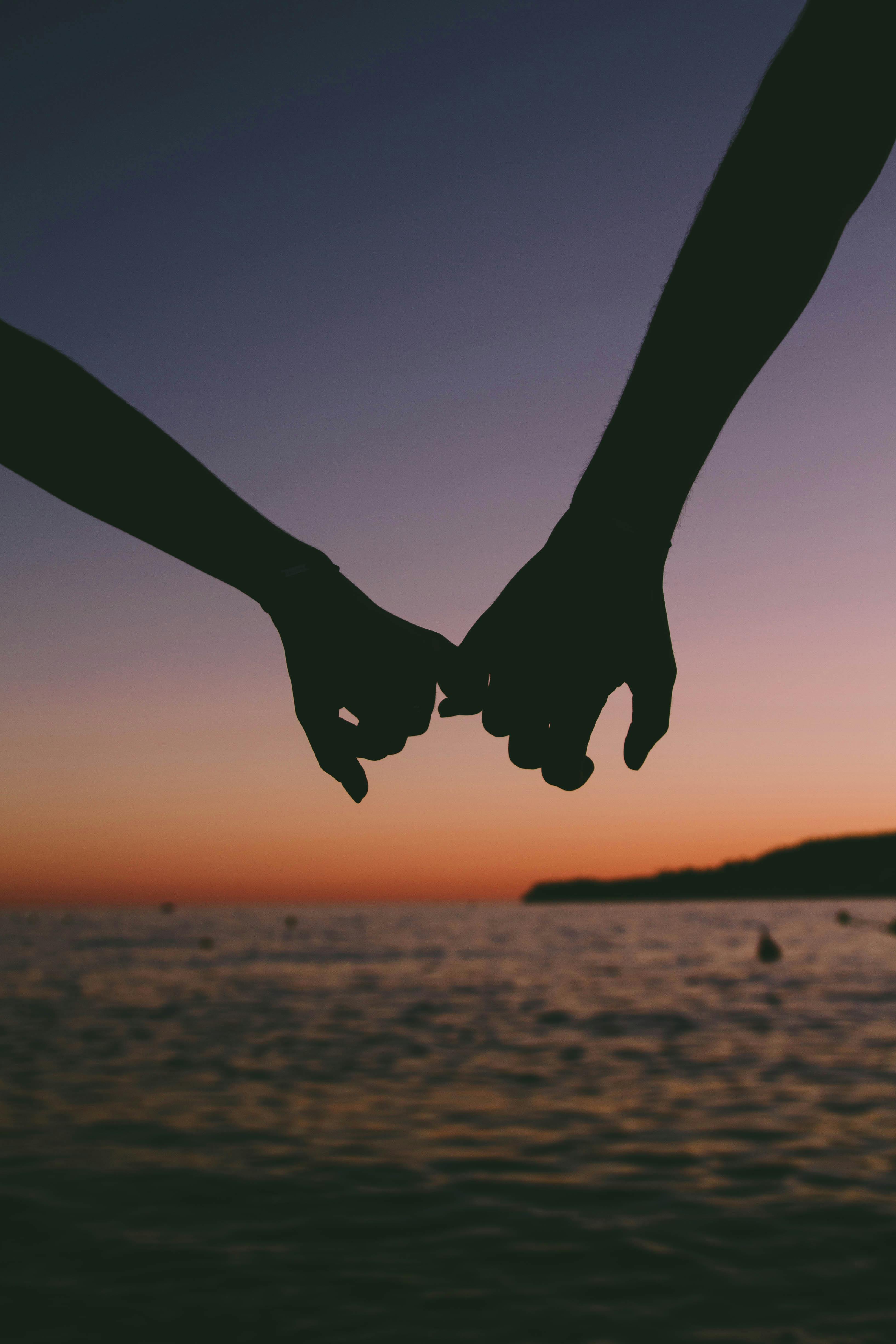 Silhouette on a marine sunset background. Couple in love at the bright  sunset touching each other Stock Photo - Alamy