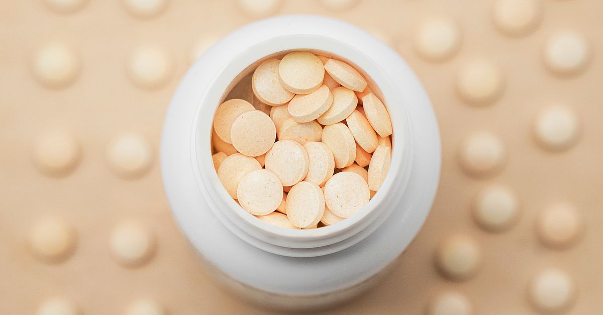 High-angle shot of a white bottle filled with round tablets on a textured background. - Evidence evidence guide for Vitamin C Supplementation: What the Evidence Says