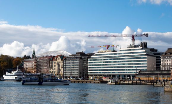 Panoramic view of Helsinki harbor featuring boats and urban waterfront architecture.