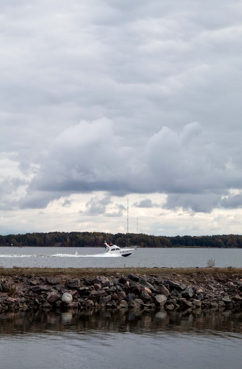 Motorboat Sailing on Lake under Cloudy Sky