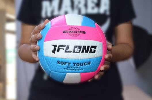Bright volleyball held in hands, showcasing a soft touch design in Lugones, España.