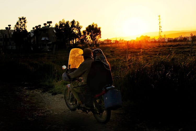 A Couple Riding A Motorcycle