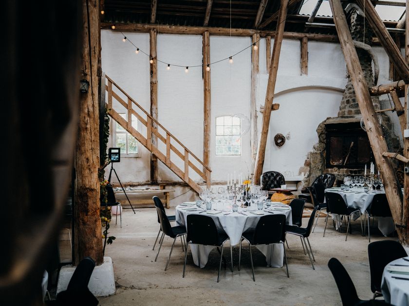 Minimal reception tables with wooden chairs awaiting guests