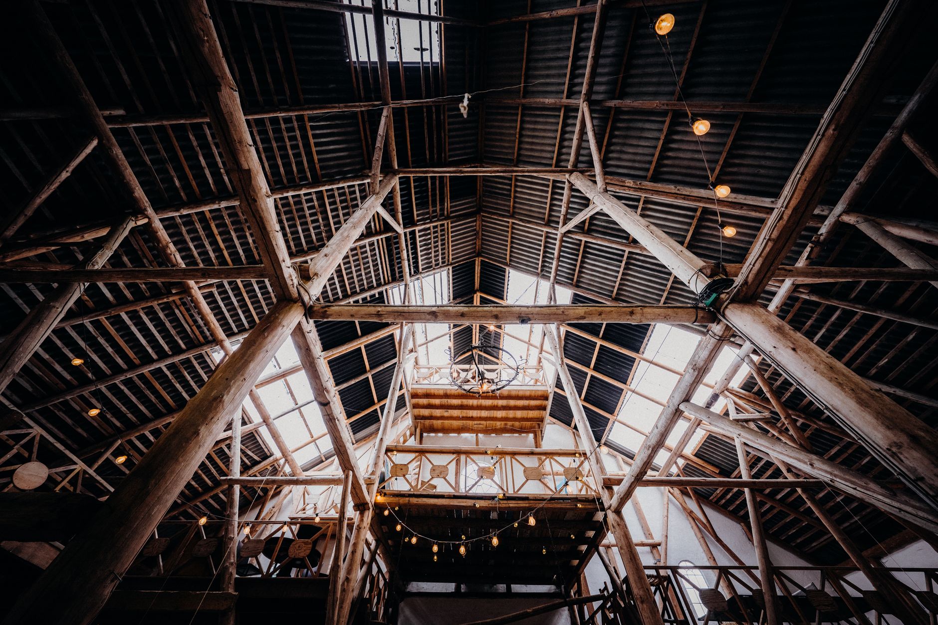 Post-frame pole barn under construction with wood posts and open roof trusses