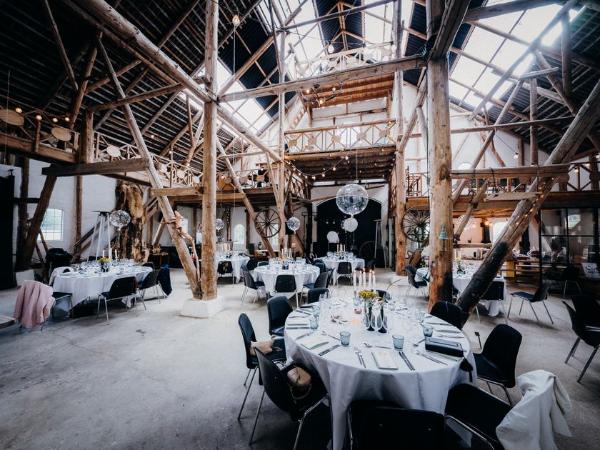 Banquet rounds and timber beams dressed for a company anniversary