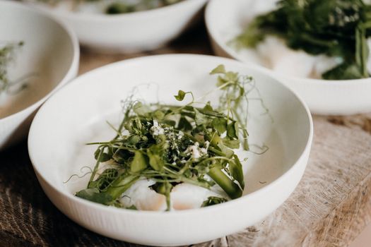 Delicious close-up of a fresh herb salad with asparagus in a white bowl, ideal for culinary blogs.