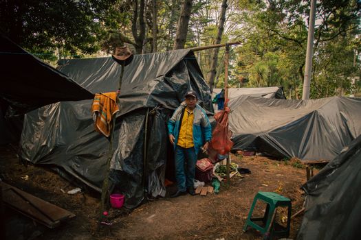 Man Wearing a Blue Jacket Standing outside a Tent