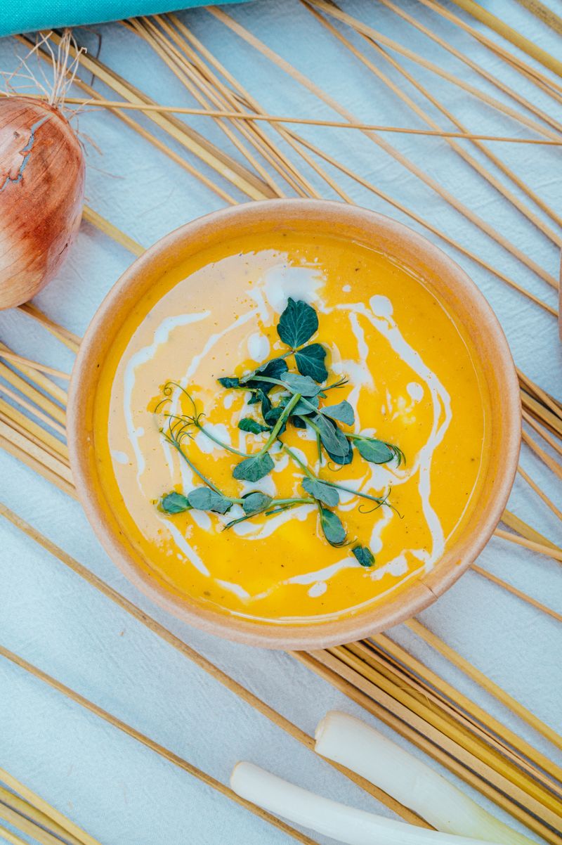 Creamy pumpkin soup garnished with fresh herbs