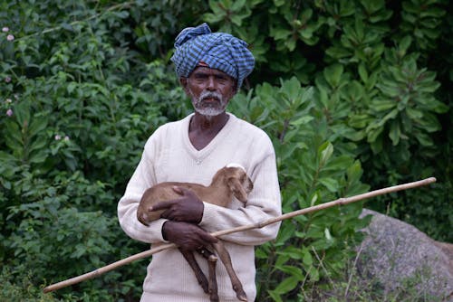 Man Wearing Turban and Holding a Goat 