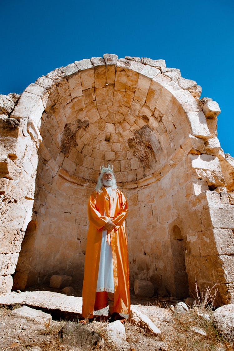 Man In A King Costume Standing In Historical Ruins 