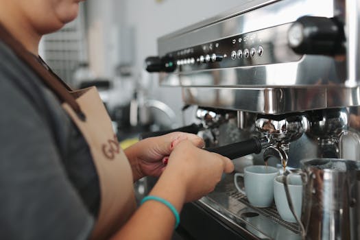 A barista skillfully prepares coffee using an espresso machine in a modern cafe setting.