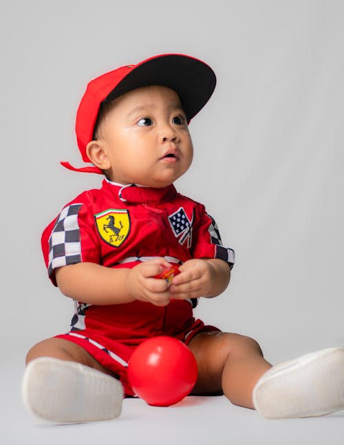 Close Up Shot of a Boy in Red Racing Suit