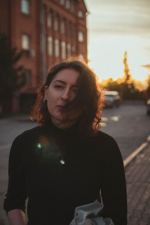 Free Sunlit portrait of woman outdoors at golden hour, capturing natural beauty and moody ambiance. Stock Photo