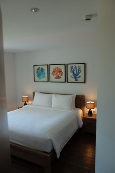 A bright and cozy bedroom interior featuring modern artwork and minimalistic design for comfort and style.