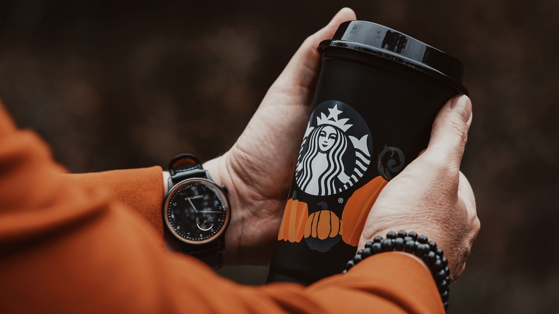 Close-Up Shot of a Person Holding a Black Starbuck Coffee Cup