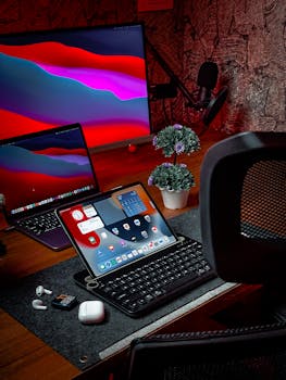 Cozy home office setup featuring iPad, MacBook, AirPods, and desktop with vibrant display.