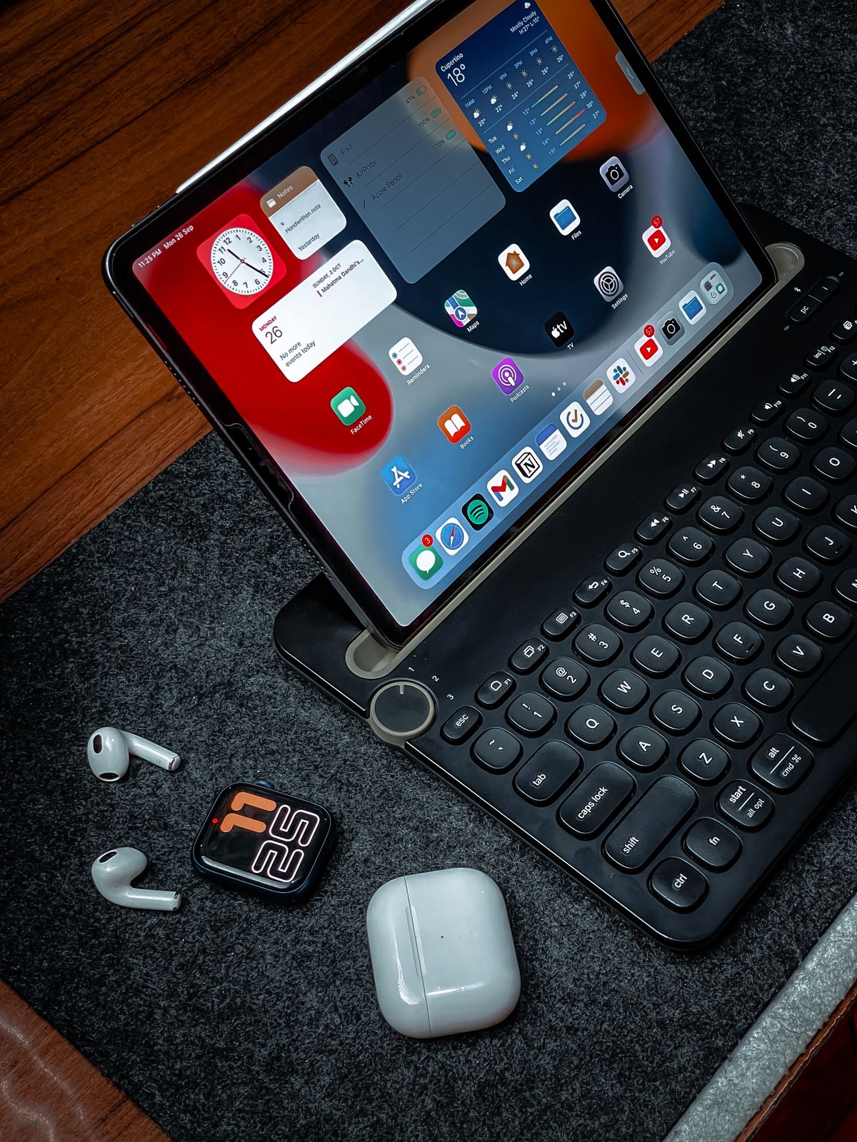 Tablet, wireless earbuds, and smartwatch arranged in a digital workspace