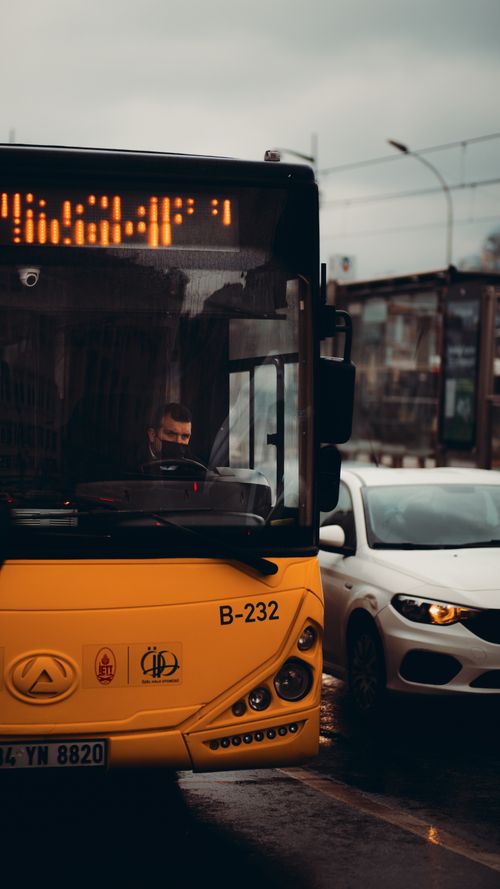 Free A bus and car in rainy Istanbul city traffic, highlighting public transport during COVID-19. Stock Photo