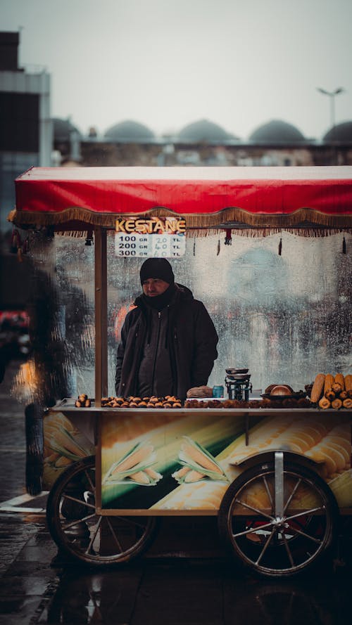 Man in Black Jacket Standing Near Food Stall