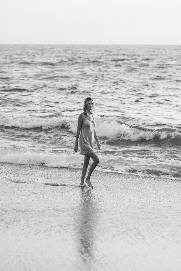 Black And White Photo Of Woman Walking On Shore