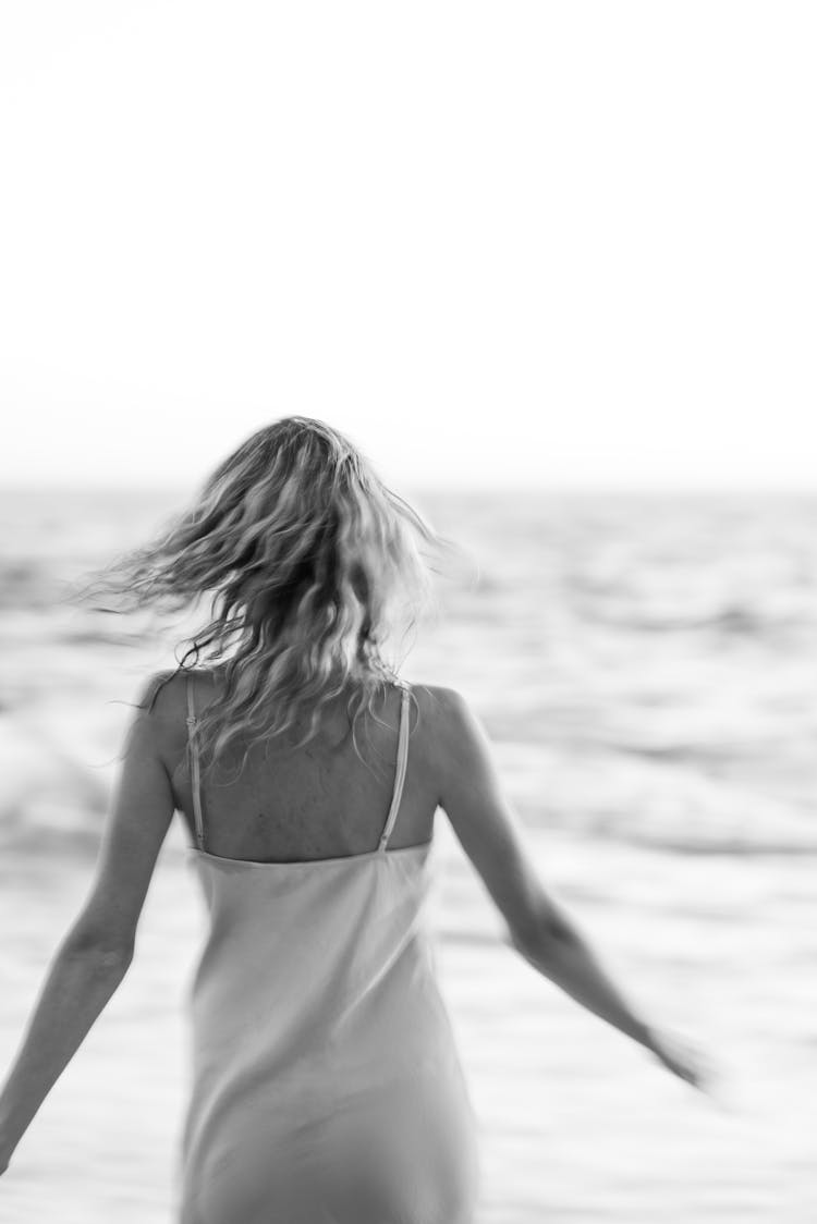 Back View Of A Woman Walking On The Beach