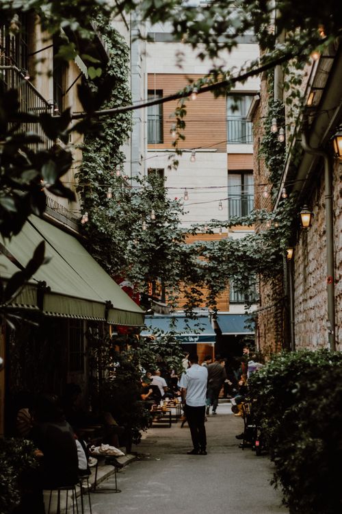 Free Discover a quaint alleyway in Istanbul featuring outdoor dining and lush greenery. Stock Photo