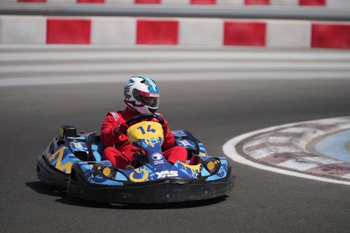 Man in Racing Uniform Riding a Go Kart