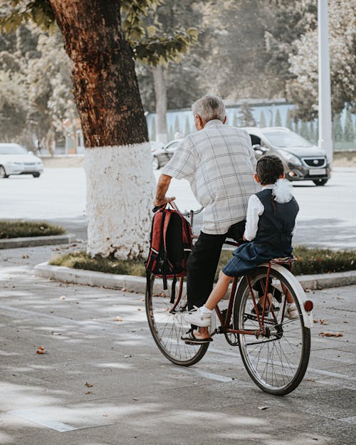 An Old Man and a Child Riding a Bike