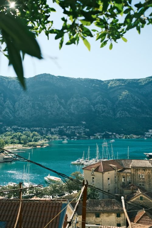 Free Beautiful view of Kotor Bay with mountains and docked sailboats under a clear sky. Stock Photo