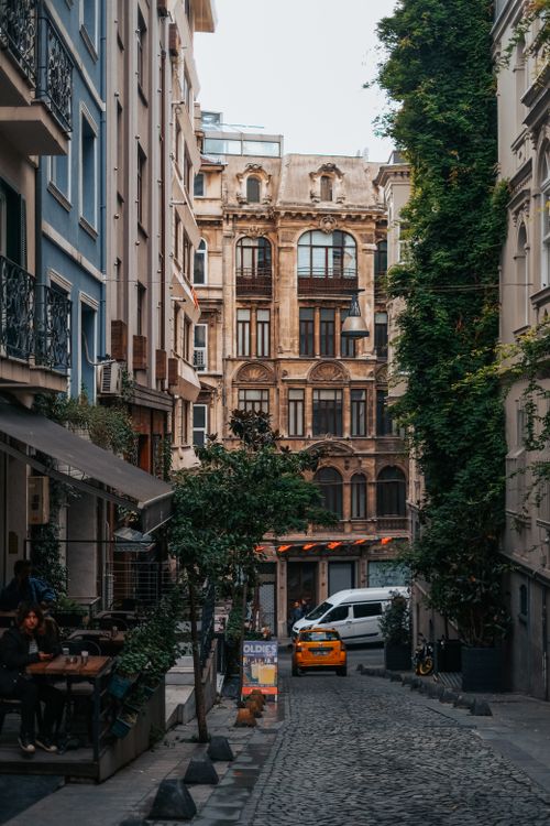 Free Quaint alleyway in Europe featuring historic architecture, cobblestones, and urban greenery. Stock Photo