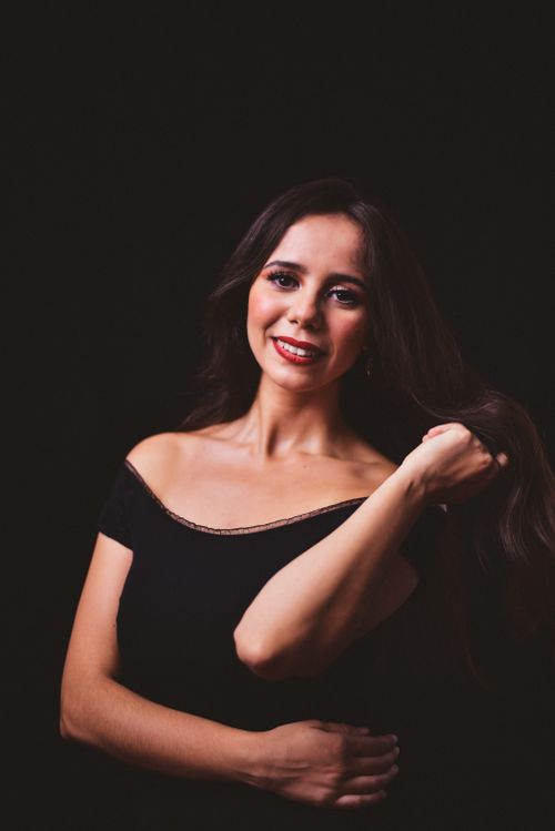 Free Elegant woman in black top posing with a smile, studio shot. Stock Photo