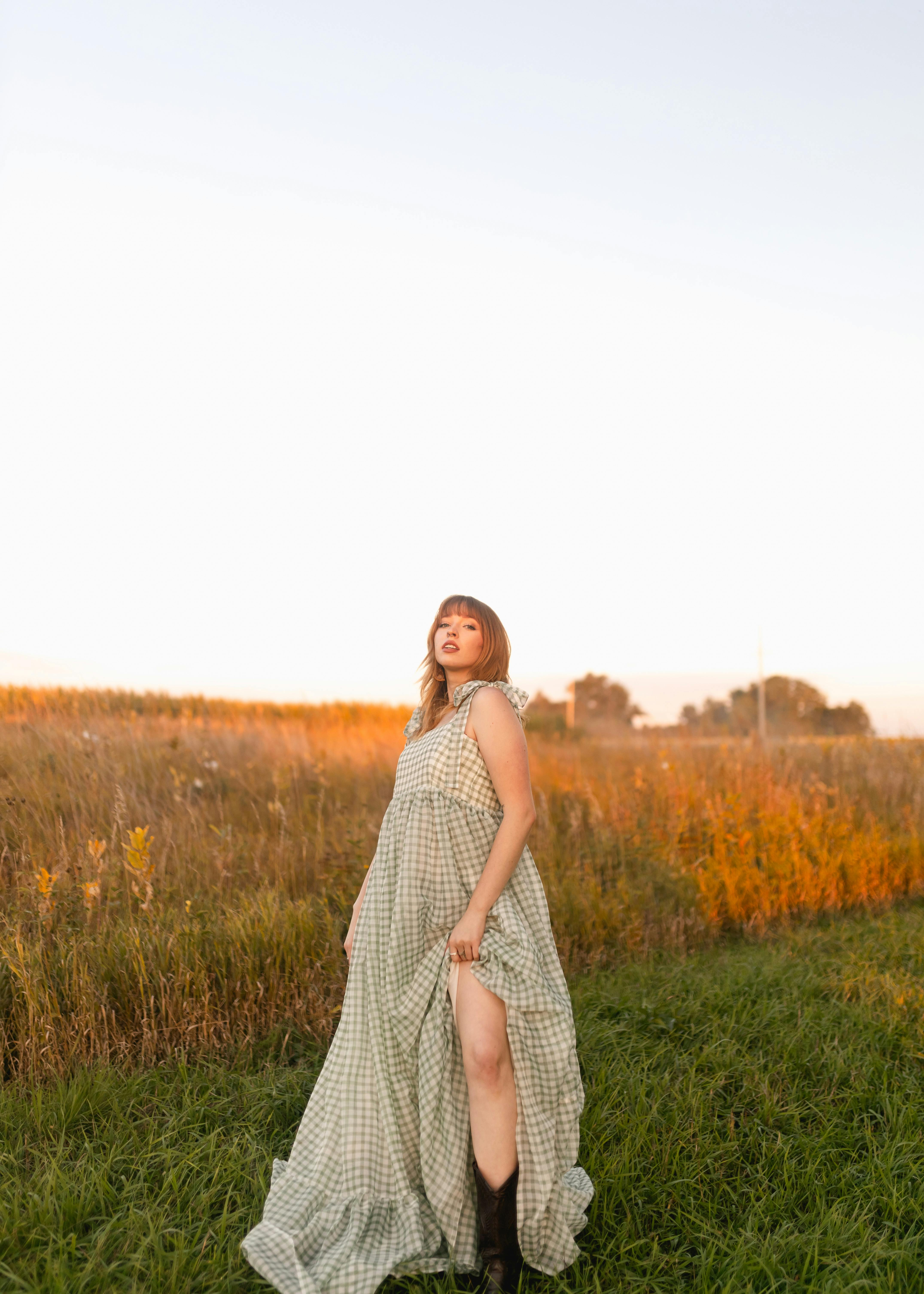 Woman in Checkered Dress Standing in the Field · Free Stock Photo