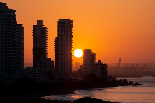 Free Dramatic sunset over Cartagena de Indias skyline, showcasing high-rise silhouettes by the sea. Stock Photo