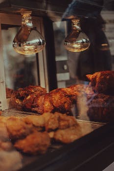 A tempting display of roasted chicken under warm lights at a Ciudad de México restaurant.